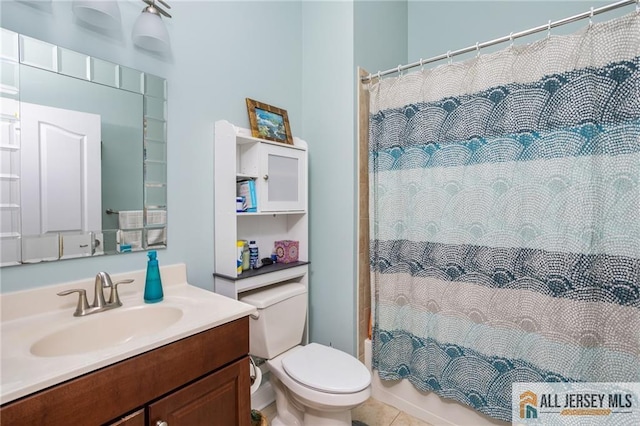 bathroom with tile patterned flooring, vanity, and toilet