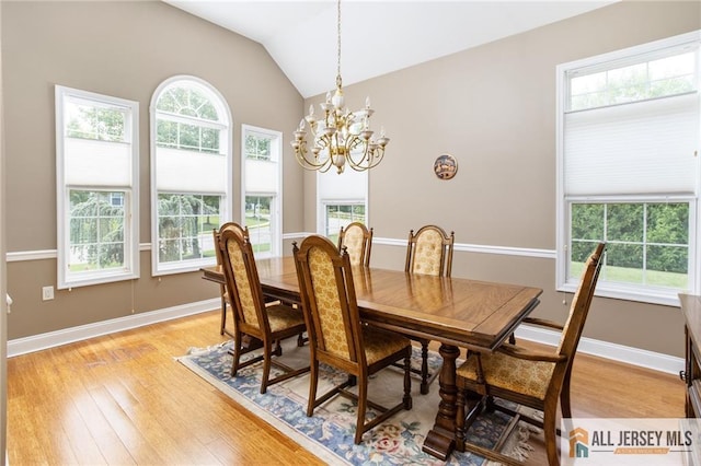 dining area featuring baseboards, a healthy amount of sunlight, vaulted ceiling, and light wood finished floors