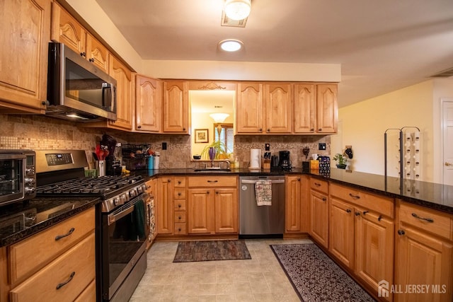 11 Drexel Ter, Monroe, NJ 08831 - kitchen featuring stainless steel appliances, dark stone countertops, decorative backsplash, a sink, and a peninsula