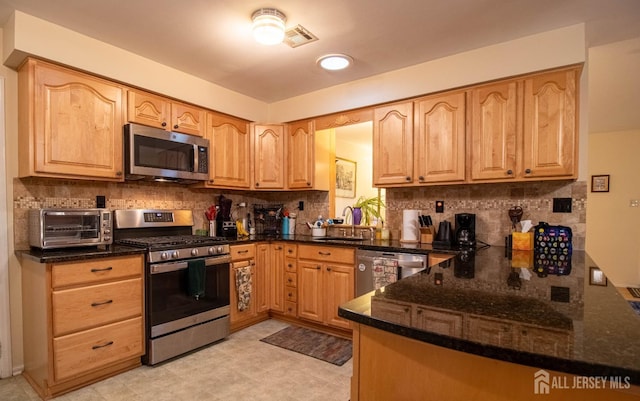11 Drexel Ter, Monroe, NJ 08831 - kitchen with appliances with stainless steel finishes, a sink, tasteful backsplash, and dark stone countertops