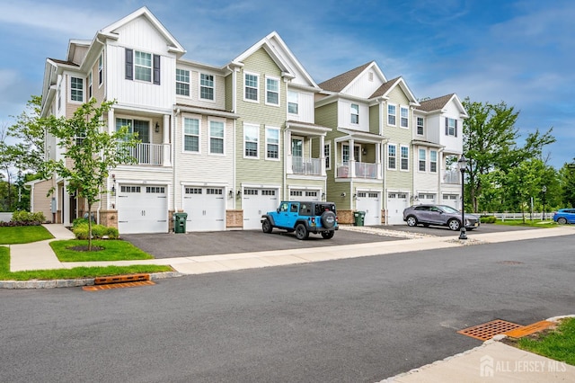 224 Park Ln, Dunellen, NJ 08812 - townhome / multi-family property featuring an attached garage, driveway, a residential view, and board and batten siding