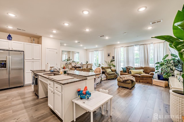 224 Park Ln, Dunellen, NJ 08812 - kitchen featuring stainless steel appliances, a kitchen island with sink, stone countertops, white cabinets, and recessed lighting