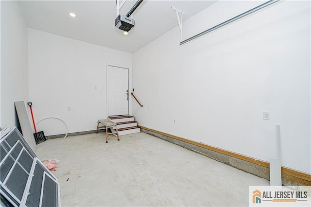 garage featuring a garage door opener and baseboards