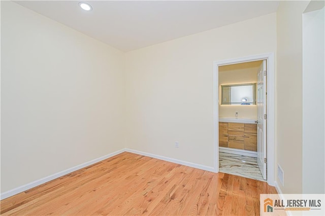 unfurnished room featuring light wood-type flooring, baseboards, and recessed lighting