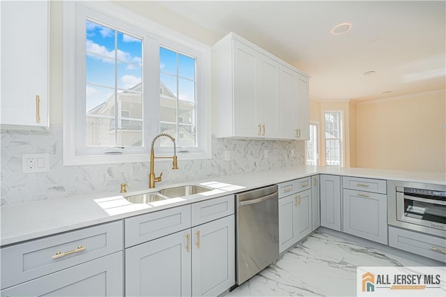 kitchen featuring dishwasher, wall oven, light marble finish floors, a sink, and light countertops