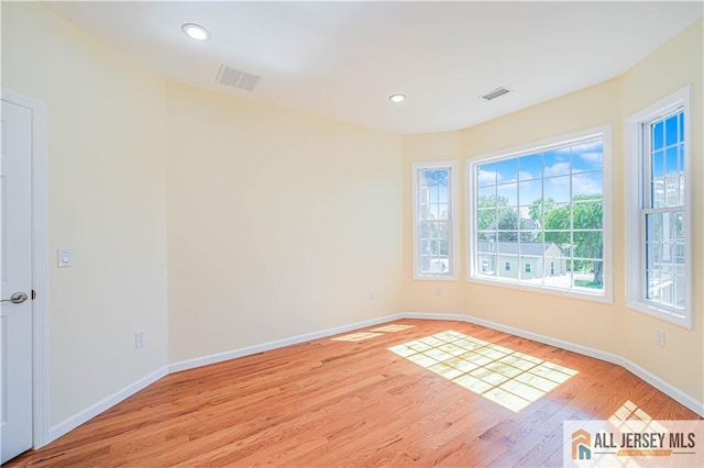unfurnished room with light wood-style floors, baseboards, and recessed lighting