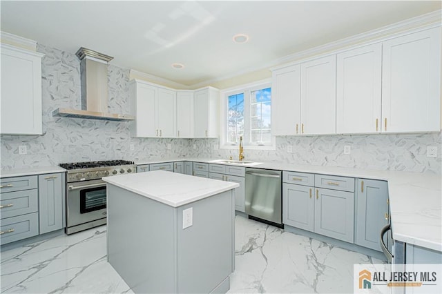 kitchen with stainless steel appliances, wall chimney exhaust hood, a sink, decorative backsplash, and light marble finish flooring