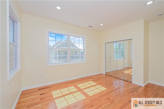 spare room featuring light wood-type flooring, baseboards, and recessed lighting
