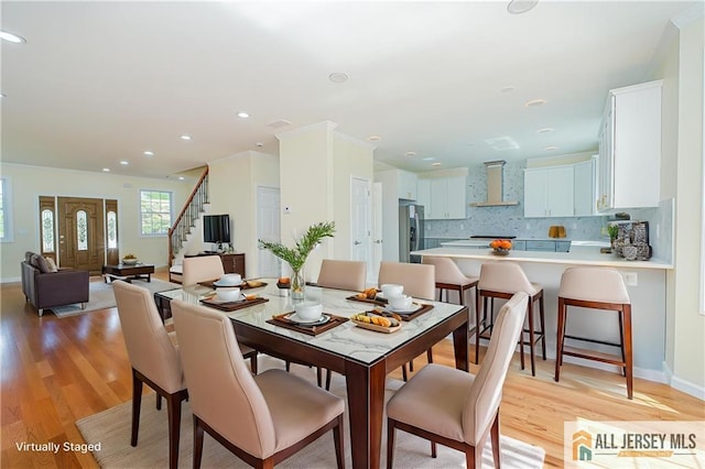 dining area featuring light wood-style flooring, stairway, baseboards, and recessed lighting