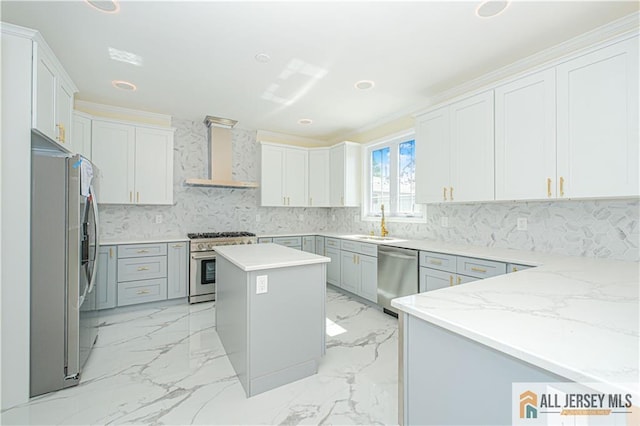 kitchen featuring appliances with stainless steel finishes, wall chimney exhaust hood, a sink, tasteful backsplash, and a center island