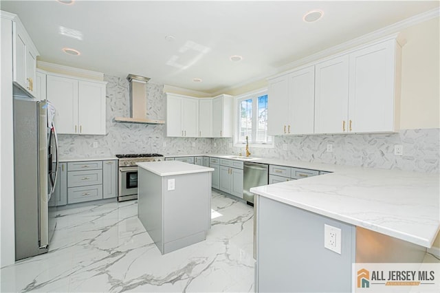 kitchen with appliances with stainless steel finishes, wall chimney exhaust hood, backsplash, a peninsula, and recessed lighting