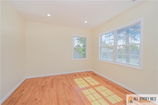 unfurnished room featuring light wood-style flooring, baseboards, and recessed lighting