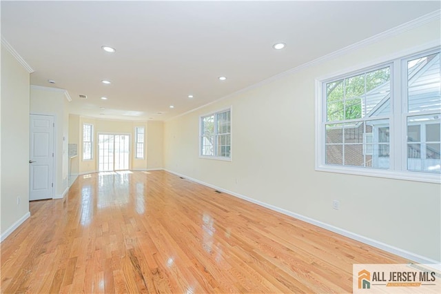 spare room featuring ornamental molding, baseboards, healthy amount of natural light, light wood finished floors, and recessed lighting