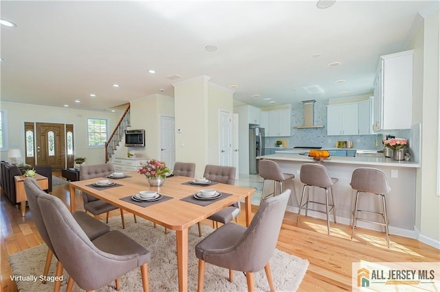 dining area with light wood-style flooring, stairway, and recessed lighting