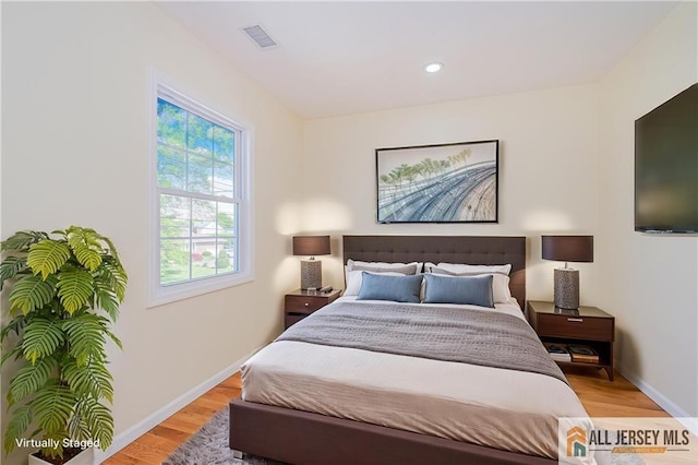 bedroom featuring light wood finished floors, baseboards, and recessed lighting