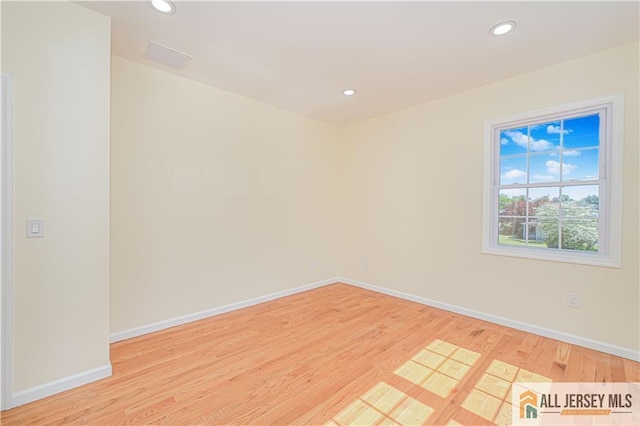 empty room with light wood-style flooring, baseboards, and recessed lighting