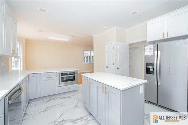 kitchen with stainless steel appliances, ornamental molding, light stone countertops, a center island, and a peninsula