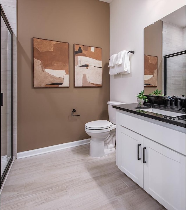 bathroom with vanity, toilet, and an enclosed shower