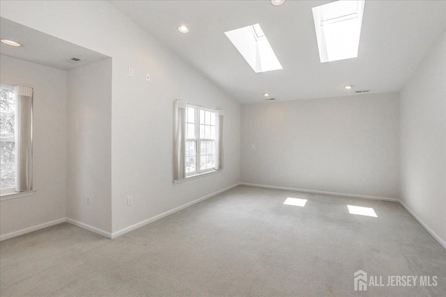 24 Hanna Ln, Old Bridge, NJ 08879 - spare room with plenty of natural light, light colored carpet, a skylight, vaulted ceiling, and recessed lighting