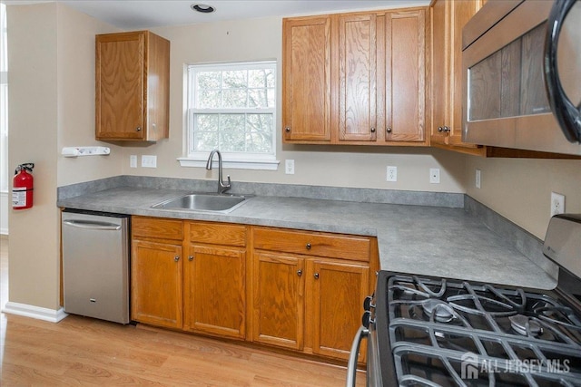 24 Hanna Ln, Old Bridge, NJ 08879 - kitchen featuring stainless steel appliances, brown cabinetry, and light wood finished floors