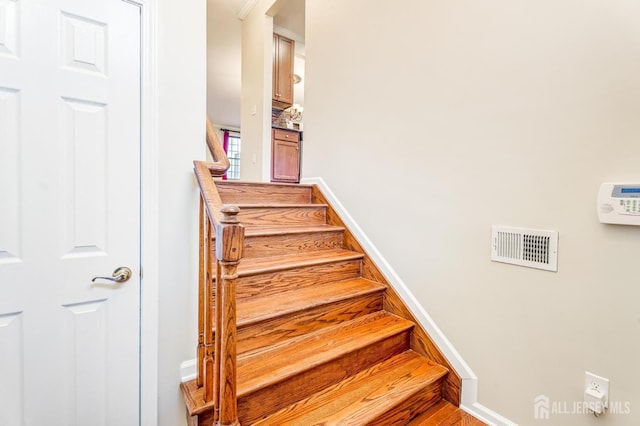 stairs featuring baseboards and visible vents