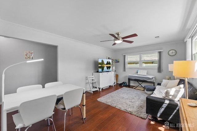 living area featuring ceiling fan, crown molding, dark wood-style floors, and healthy amount of natural light