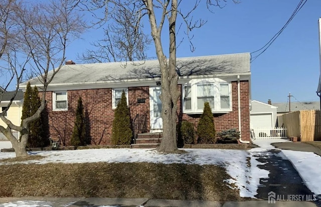 16 Holmes St, Carteret, NJ 07008 - view of front of house featuring brick siding, driveway, a chimney, and a shingled roof