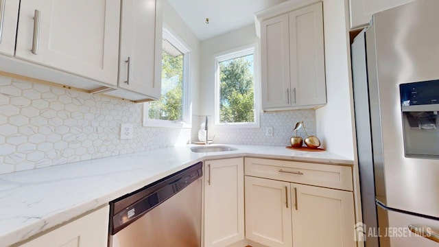 15-A Avenue B, Helmetta, NJ 08828 - kitchen with stainless steel appliances, a sink, decorative backsplash, and light stone counters