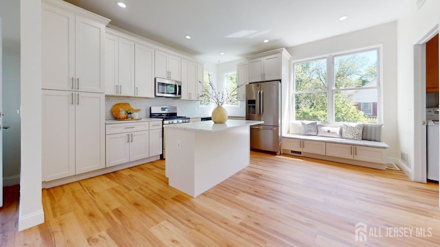 15-A Avenue B, Helmetta, NJ 08828 - kitchen featuring stainless steel appliances, decorative backsplash, light wood-type flooring, light countertops, and a kitchen island
