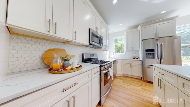 15-A Avenue B, Helmetta, NJ 08828 - kitchen with appliances with stainless steel finishes, tasteful backsplash, white cabinets, a sink, and light stone counters
