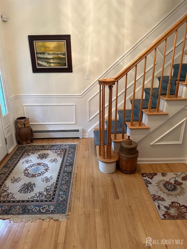 140 Bunker Hill Rd, Franklin Twsp, NJ 08540 - stairway with baseboard heating, wood-type flooring, and a decorative wall