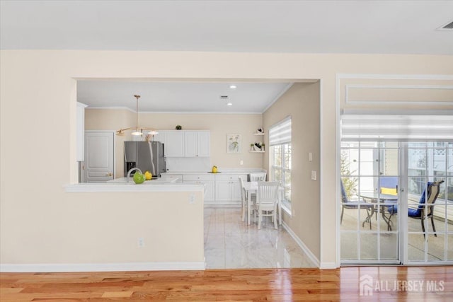 595 Waterside Blvd, Monroe, NJ 08831 - kitchen featuring a peninsula, stainless steel fridge, baseboards, white cabinetry, and light countertops