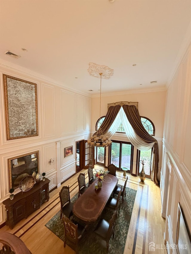 34 Line Rd, Holmdel, NJ 07733 - dining area featuring light wood-style floors, a decorative wall, and ornamental molding