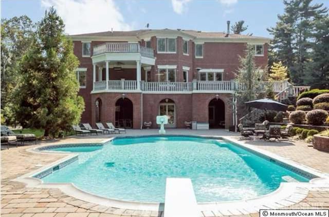 34 Line Rd, Holmdel, NJ 07733 - back of property featuring a balcony, a patio, and an outdoor pool