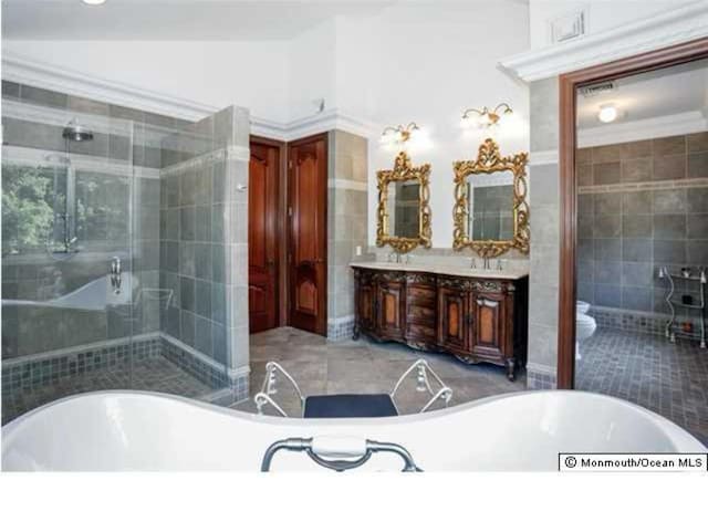 34 Line Rd, Holmdel, NJ 07733 - bathroom with tile walls, double vanity, a soaking tub, and a stall shower