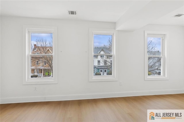 bonus room with baseboards, visible vents, a wealth of natural light, and wood finished floors