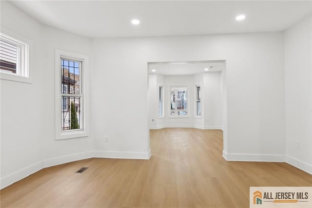 spare room with recessed lighting, light wood-style flooring, and baseboards