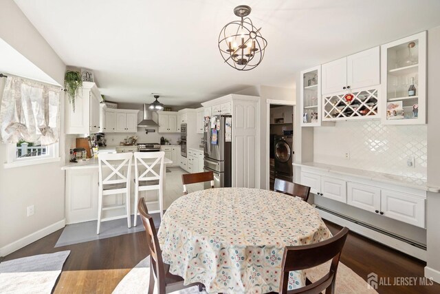 242 Green St, Old Bridge, NJ 08857 - dining area with baseboard heating, dark wood finished floors, washer / clothes dryer, a chandelier, and bar