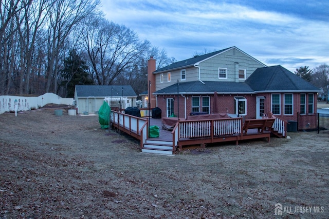 20 Wedgewood Ct, East Brunswick, NJ 08816 - rear view of property featuring a chimney, a deck, brick siding, and a fenced backyard