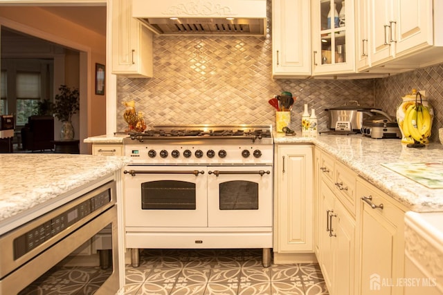 20 Wedgewood Ct, East Brunswick, NJ 08816 - kitchen featuring double oven range, decorative backsplash, light stone counters, and custom range hood