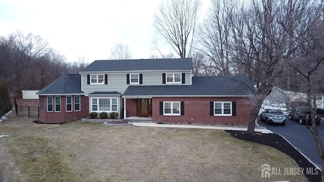 20 Wedgewood Ct, East Brunswick, NJ 08816 - traditional home with a front yard, brick siding, a shingled roof, and driveway