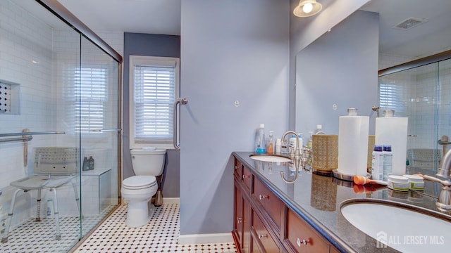 full bath with toilet, a stall shower, visible vents, and a sink