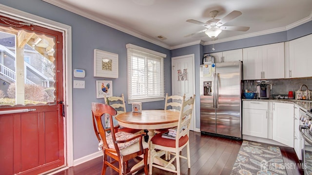 dining space featuring dark wood-style floors, baseboards, a ceiling fan, and crown molding