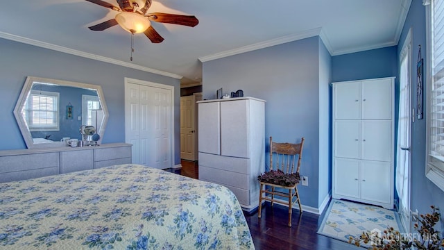 bedroom featuring dark wood finished floors, a closet, ornamental molding, a ceiling fan, and baseboards