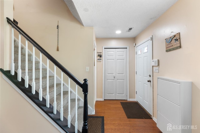 76 Lynnette Ct, South Brunswick, NJ 08824 - foyer entrance with wood finished floors, a textured ceiling, and stairway