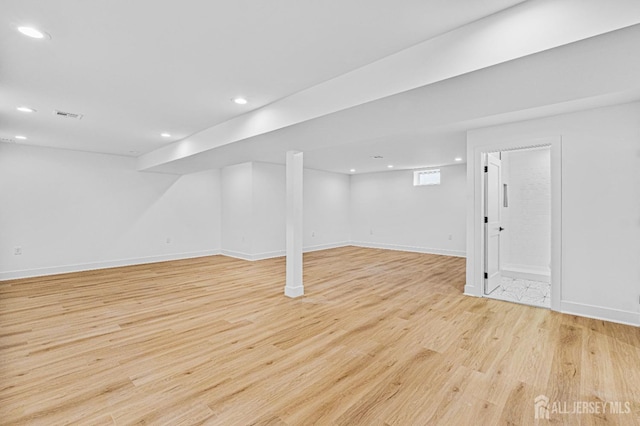 below grade area with light wood-style floors, baseboards, and recessed lighting