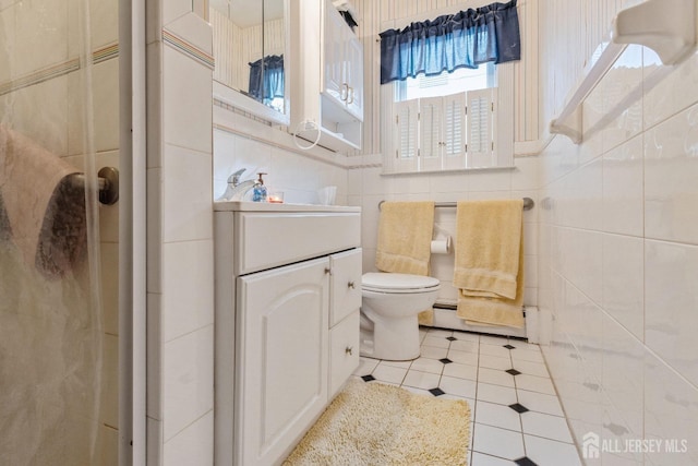 bathroom with tile walls, toilet, a stall shower, vanity, and tile patterned flooring