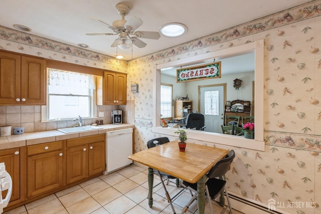 kitchen featuring wallpapered walls, white dishwasher, tile counters, and a sink