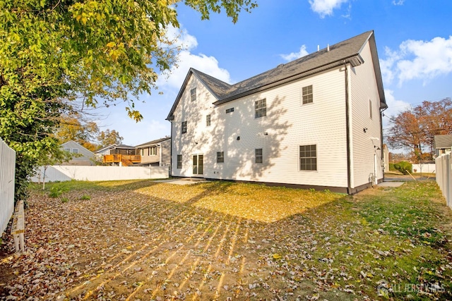 back of house featuring a fenced backyard and a yard