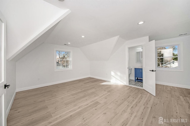 bonus room with visible vents, baseboards, vaulted ceiling, light wood-style floors, and recessed lighting